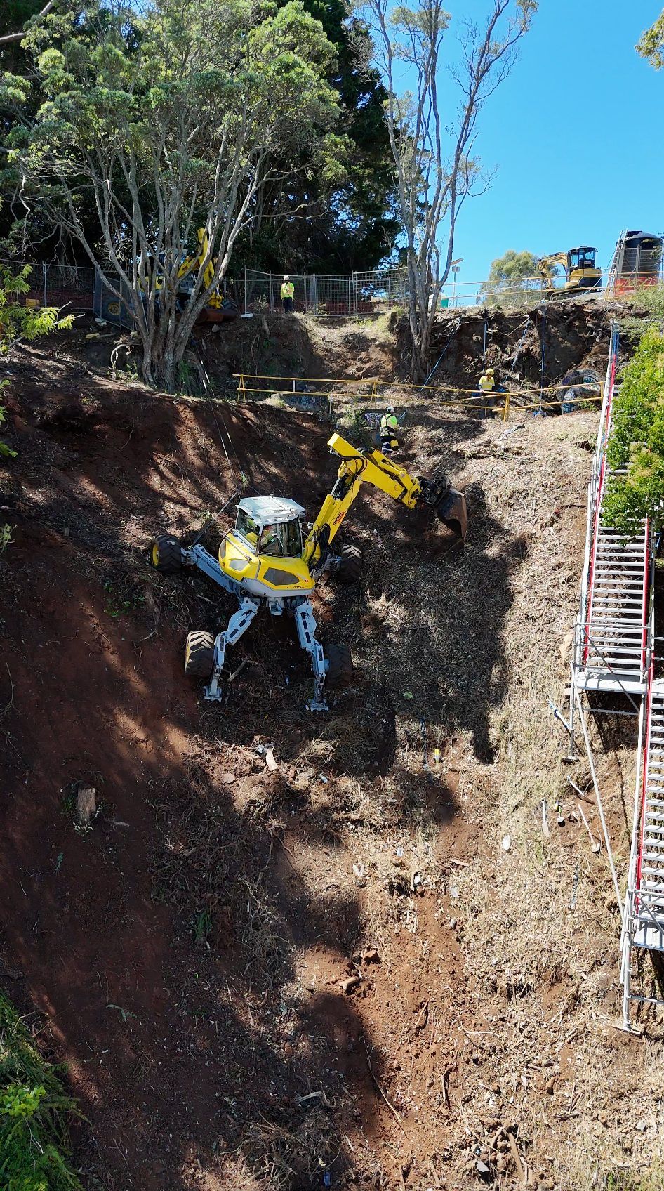 Menzi Muck working the 50-degree trench line on La Veta Ave