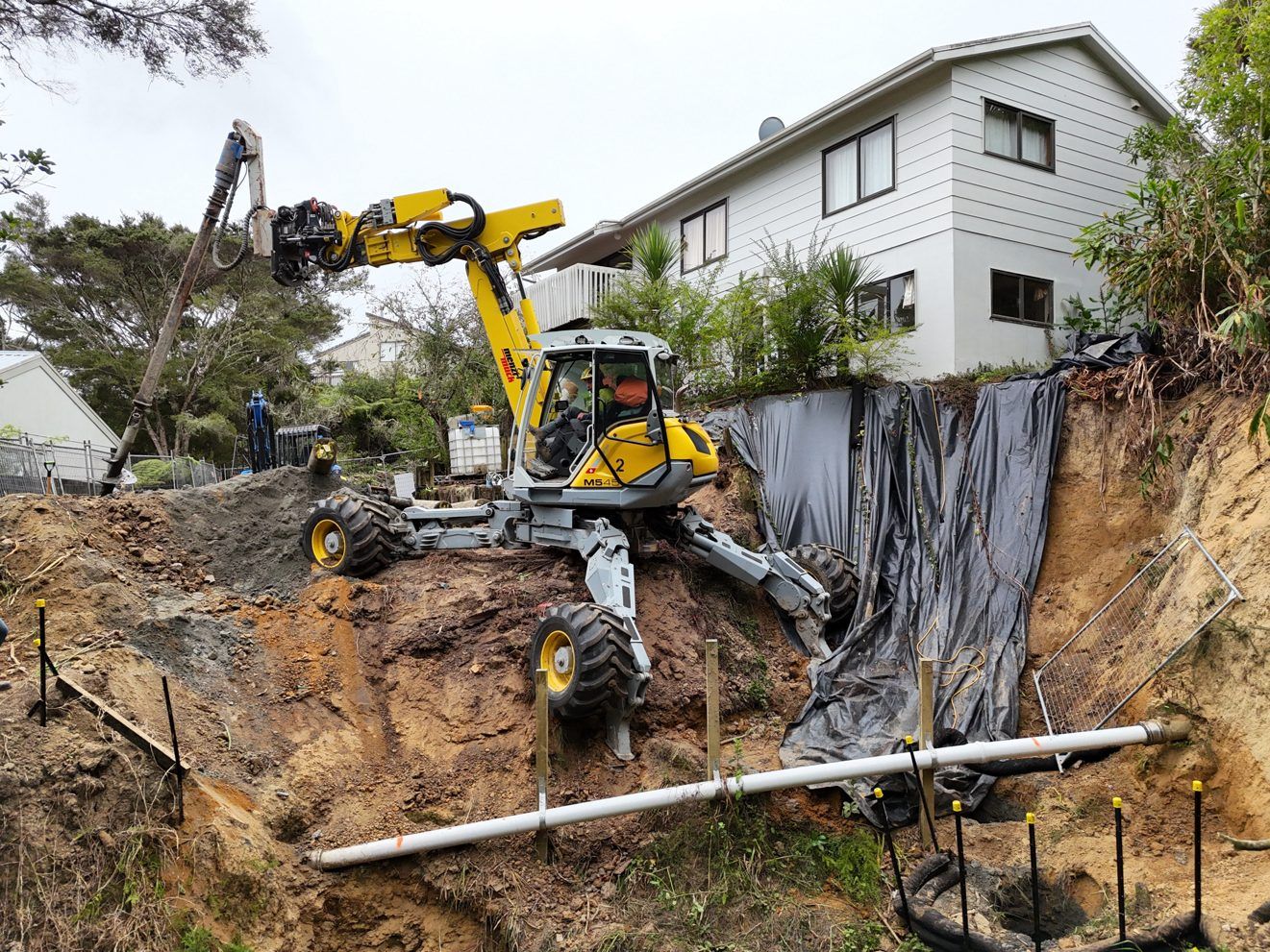 Menzi Muck drilling pile casings at Tree View Ave